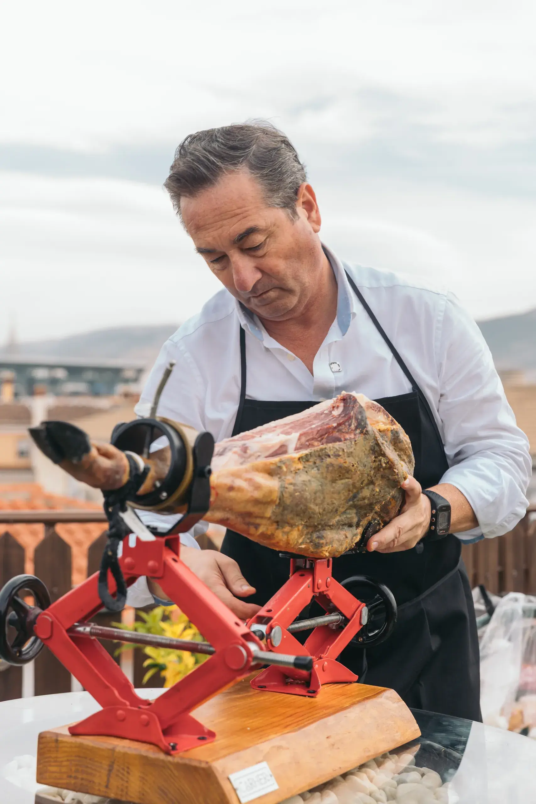 El creador coloca un jamón de forma inclinada sobre el jamonero